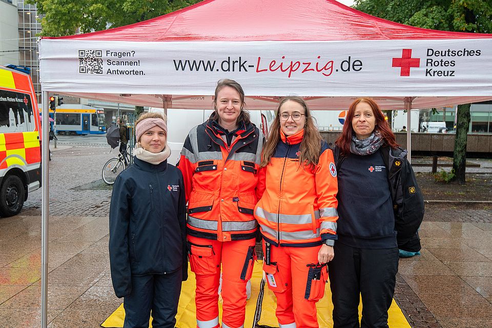 vier Frauen in DRK-Kleidung stehen vor dem DRK-Pavillon