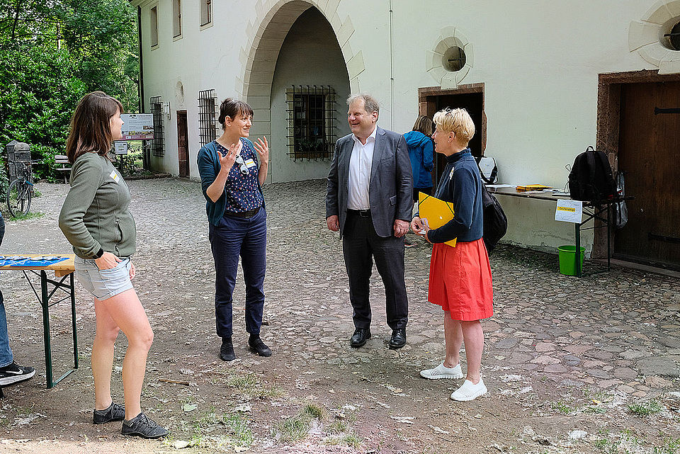 3 Frauen und ein Mann unterhalten sich vor dem Torhaus Dölitz